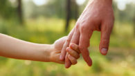 Ребенок держит за руку родителя
